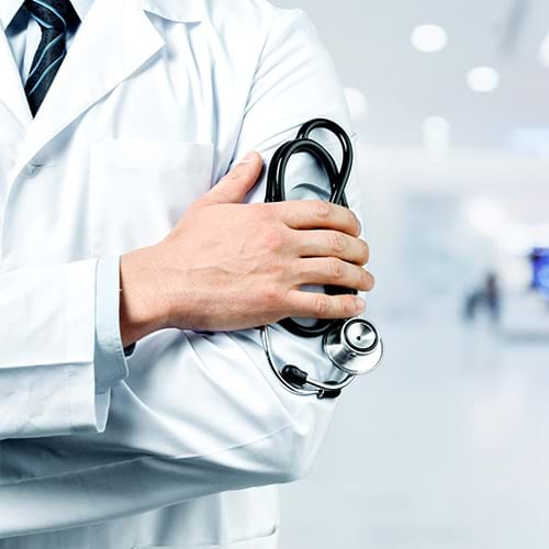 An arm view of a doctor wearing a white coat and holding a stethoscope in his hand