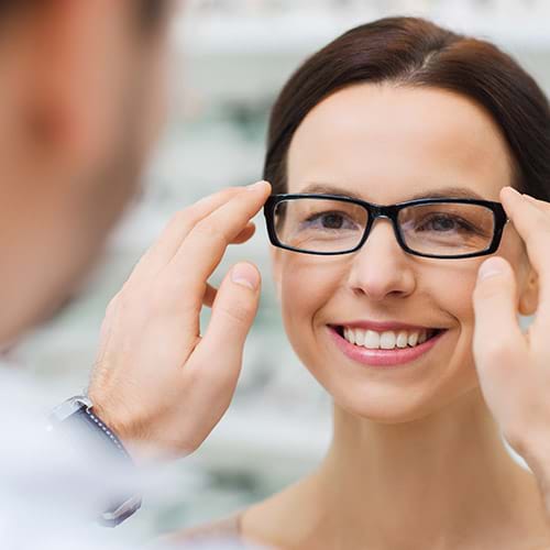 Woman trying on glasses with her eye doctor