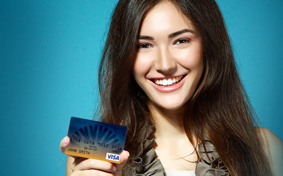 A smiling women holding a USU Credit Union reloadable card.